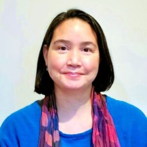 Photo of person with shoulder length brown hair and red scarf